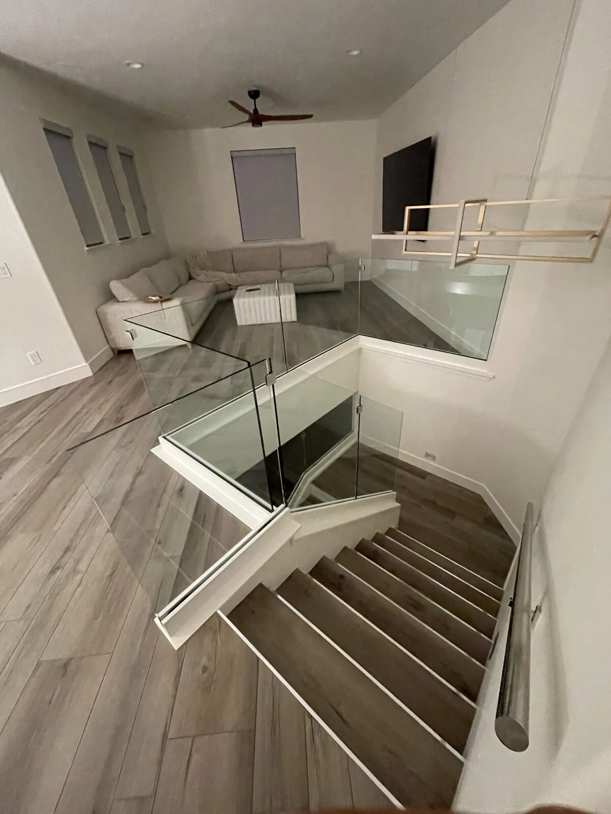 Upstairs loft with frameless glass wrapping the stair opening